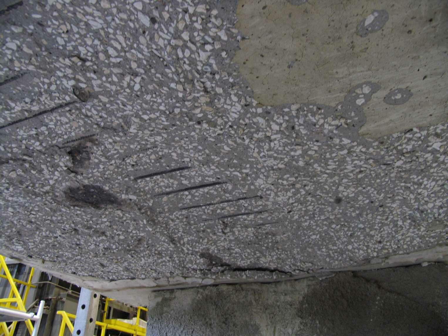 Afspatten van beton, het uiteenspringen van kleinere of grotere delen uit                        het betonoppervlak